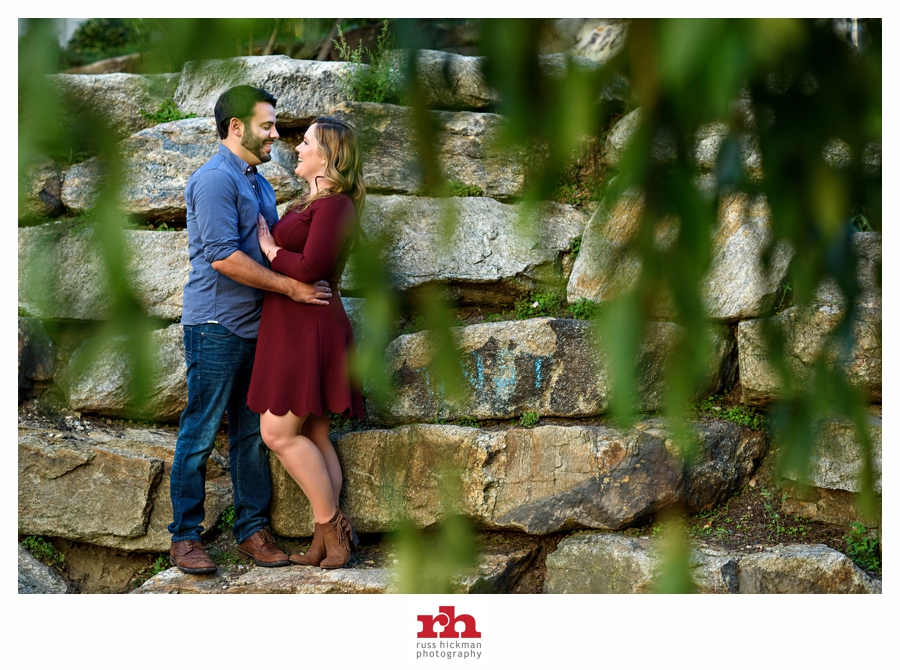 A couple pose by the rocks at boat house row in philadelphia during their engagement session.
